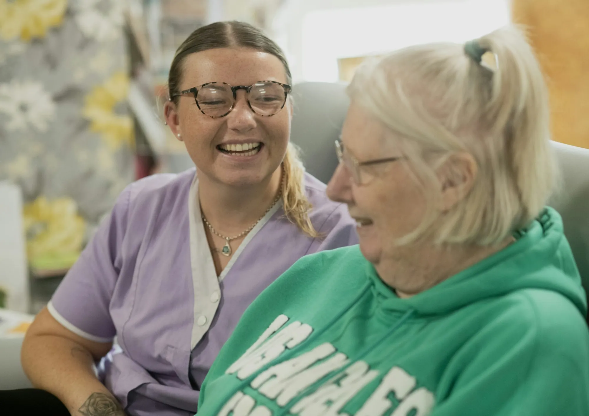 A supervisor talking with an older woman in her sitting room